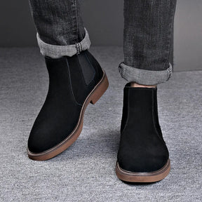 Modelo usando botas Chelsea masculinas pretas com calça jeans