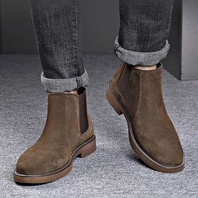 Modelo usando botas Chelsea masculinas marrons com calça jeans