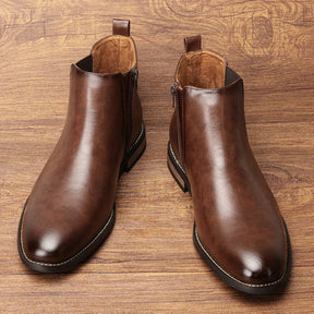Par de botas Chelsea marrons sobre piso de madeira