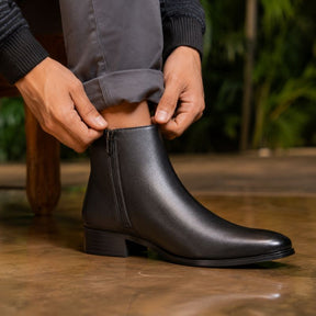 Detalhe da bota masculina preta sendo ajustada no pé