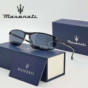 Óculos de sol Maserati apresentados sobre estojo azul, com caixa e cartão da marca ao fundo.