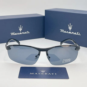 Óculos de sol Maserati com lentes azul-acinzentadas posicionados em frente a duas caixas azuis com o logotipo da marca.