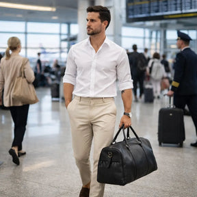modelo masculino utilizando a bolsa de viagem em couro preto pu premium valenteo vittorio em aeroporto